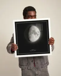 Man holding a moon phase print in a white frame